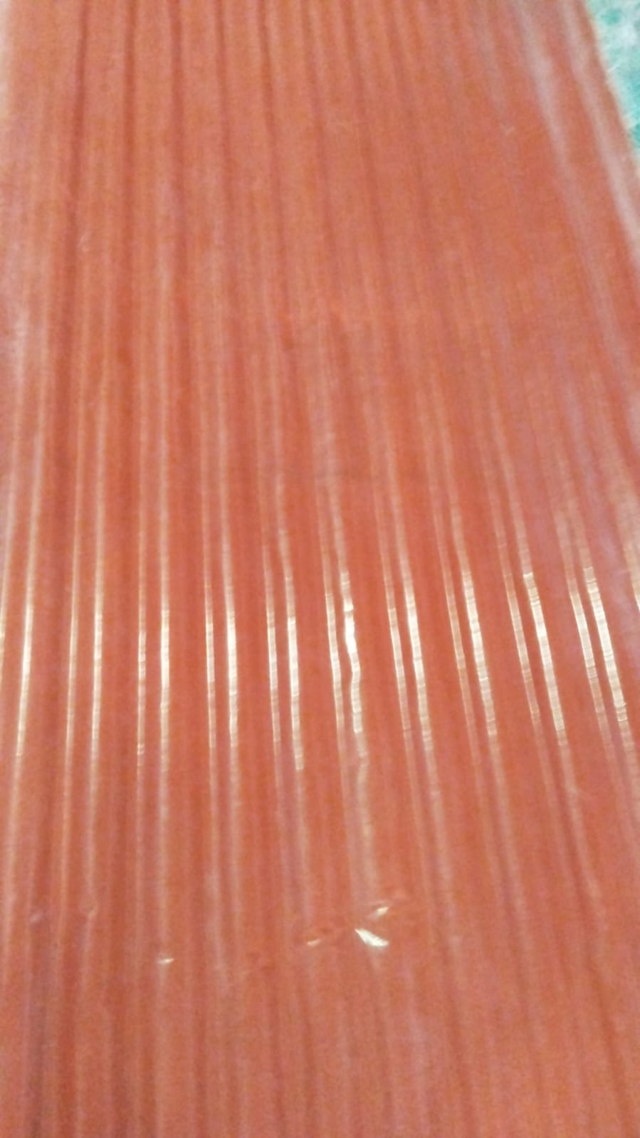Close-up of terracotta/orange FRP corrugated sheet showing ridges and valleys.