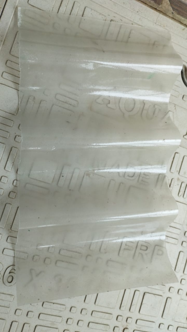 Milky white FRP corrugated sheet sample with embossed branding, showing corrugated profile.