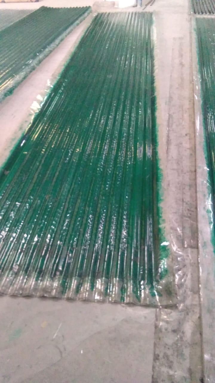 FRP corrugated sheets laid out in production/packing area, showing uniform corrugation and finish.