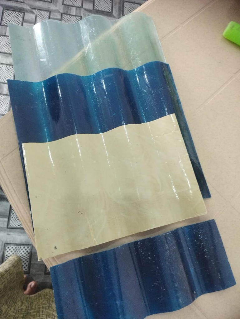 Samples of FRP corrugated roofing sheets in clear and blue tones, showing profile shape and colour options for skylights and roofing.