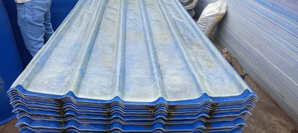Stack of blue FRP profile sheets with clear top layer, ideal for skylight bands that match metal roofing profiles.