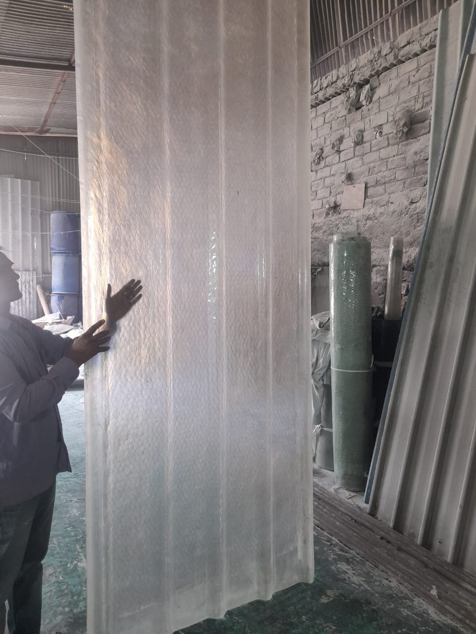 Clear FRP profile sheet panel in workshop, showing full height and corrugated ribs.