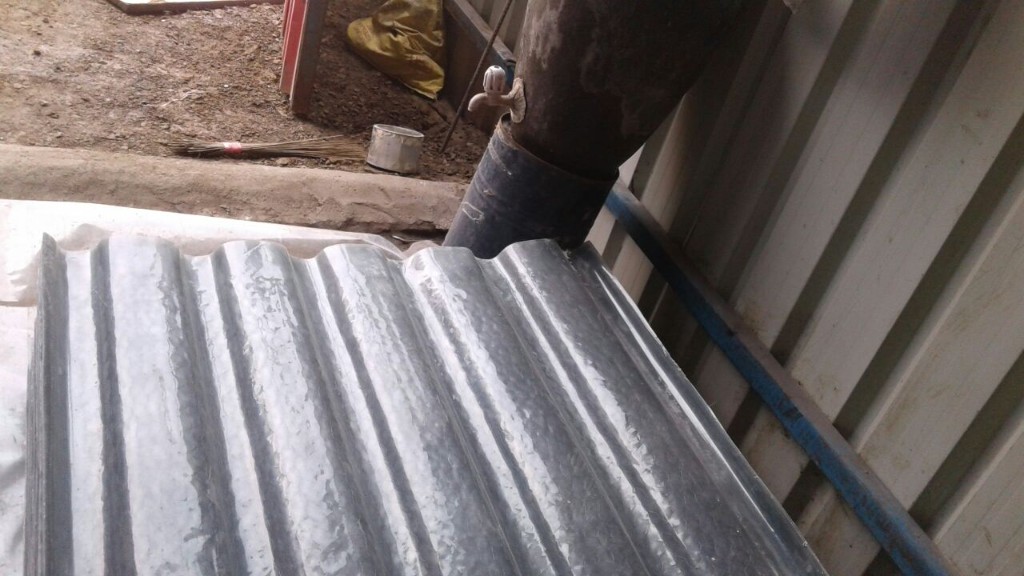 Grey FRP profile sheet during production, showing embossed surface and matching wave profile for easy installation with existing sheets.