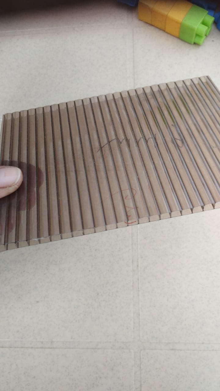 Translucent brown/grey multiwall sheet with visible ribbed structure.