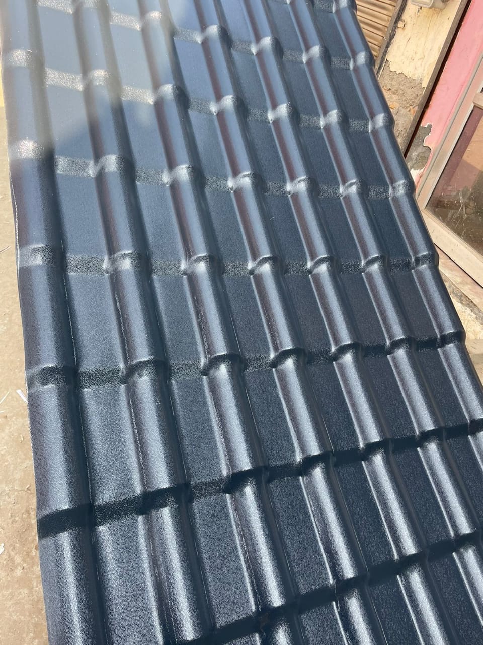 Grey UPVC tiled roof sheet close-up showing profile and finish.