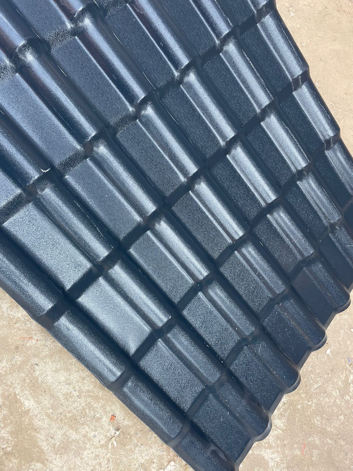 Grey UPVC tiled roof sheet detail showing tiled pattern and surface texture.